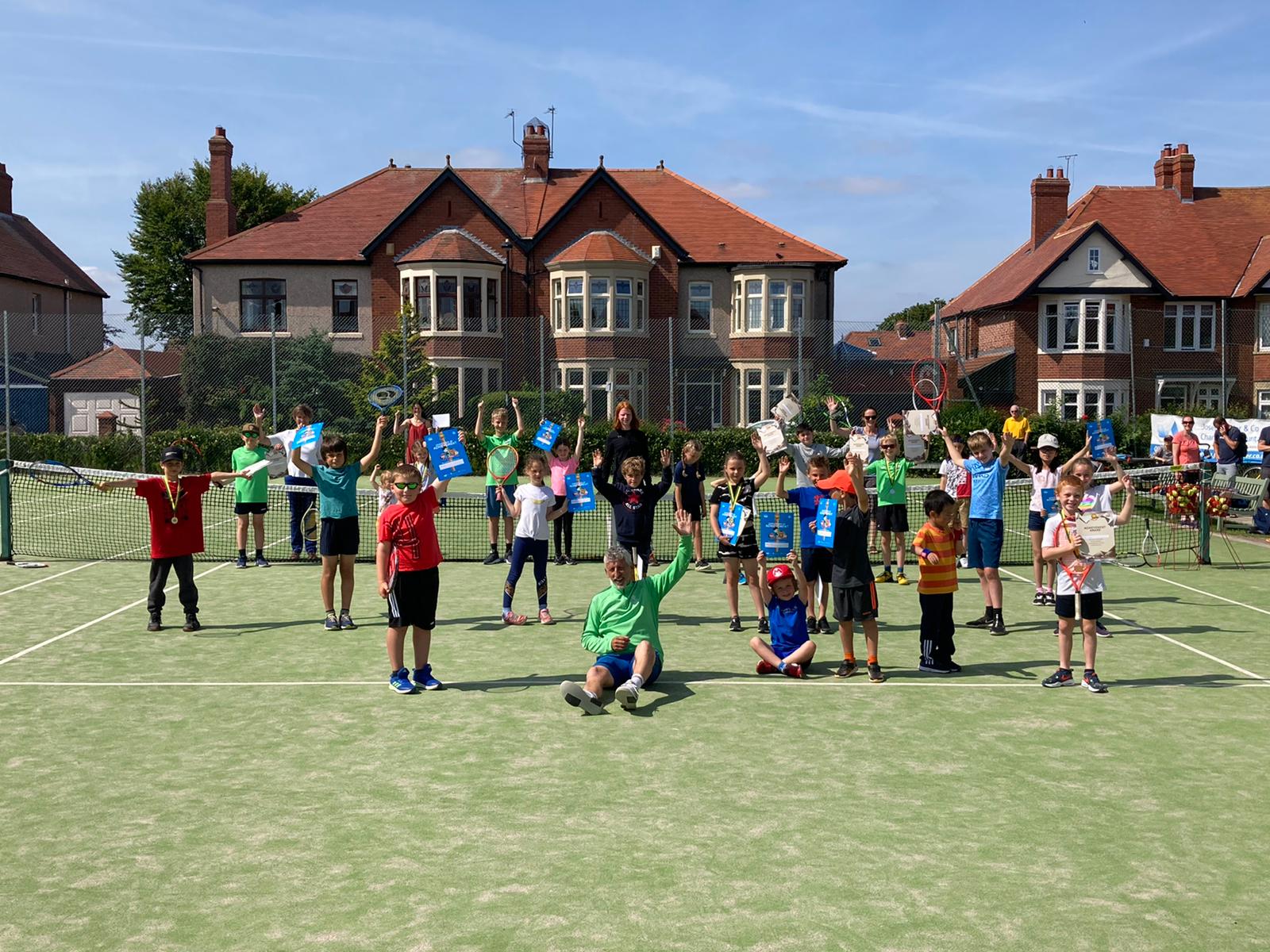 Children celebrating at a holiday tennis camp